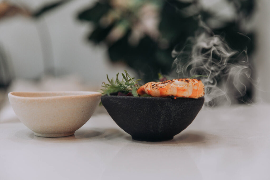 Steaming cooked prawn in black bowl